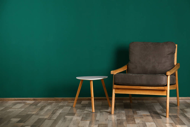 Intérieur élégant avec fauteuil et table d'appoint près du mur de couleur, espace pour le texte
 - Photo, image