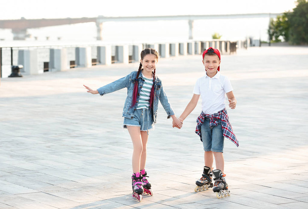 Little children roller skating on city street - Foto, imagen