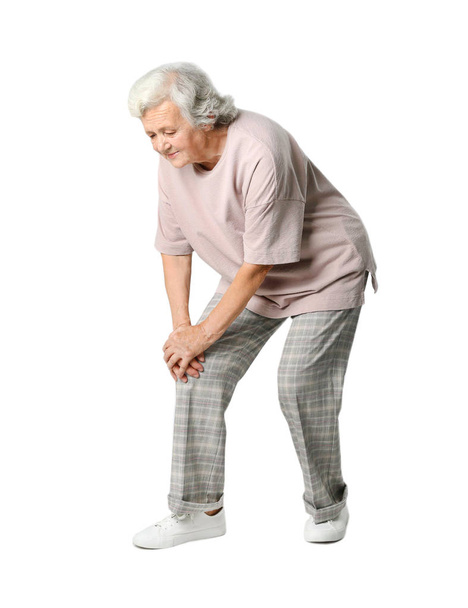 Full length portrait of senior woman having knee problems on grey background - Photo, image