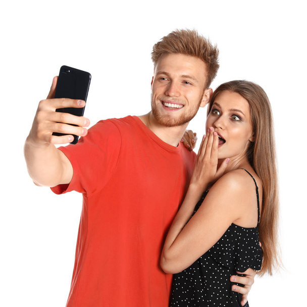 Happy young couple taking selfie on white background - Photo, image
