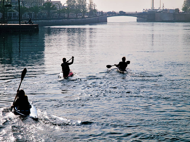 ギリシャ、チャルキダ海岸でカヌーを練習する3人の若い選手. - 写真・画像