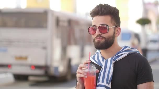 Concepto de comida callejera y vida urbana. Joven hombre barbudo sonriente sosteniendo una taza con batidos de jugo de bebida o limonada
 - Metraje, vídeo