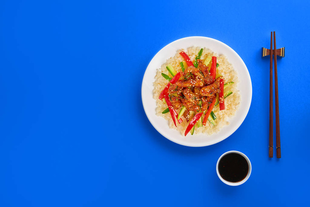 Smażone mięso z kurczaka, warzywa i ryż na kolorowym tle. Kopiuj przestrzeń, widok z góry - Zdjęcie, obraz