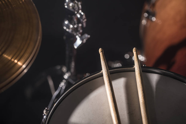 Close-up Drum definido em uma sala escura contra o pano de fundo dos holofotes. Símbolo de fundo atmosférico de tocar bateria de rock ou jazz
. - Foto, Imagem