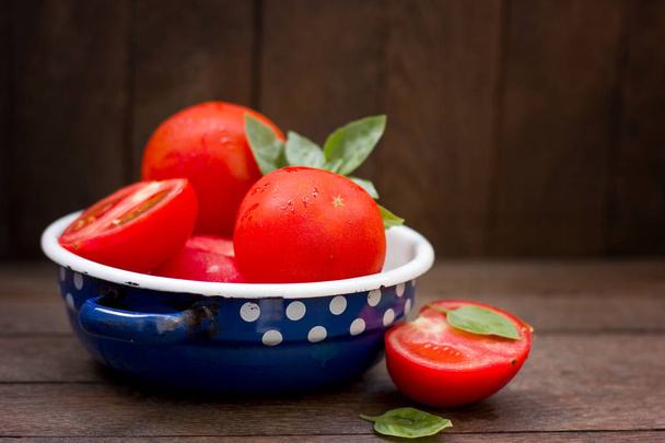 Tomate y albahaca en tazón rústico primer plano en la mesa
 - Foto, Imagen