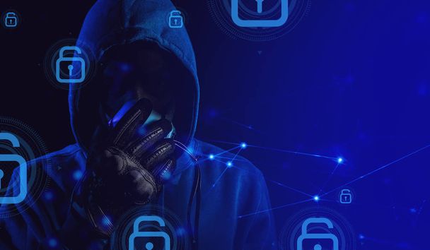 bad guy hacker with blue hood outfit and mask with glove on dark background in security virus network concept - Фото, зображення