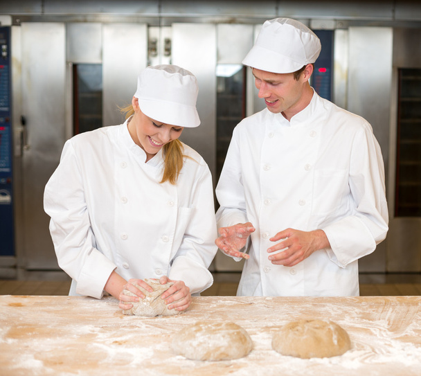Instructor and baker apprentice kneading bread dough - Foto, Bild