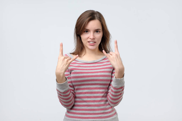 Young european woman showing rock and roll hand gesture posing in studio. - Φωτογραφία, εικόνα