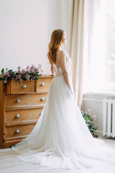  Wedding in European style. Stylish trendy bride in the Studio with a bouquet of lilacs. - Photo, image