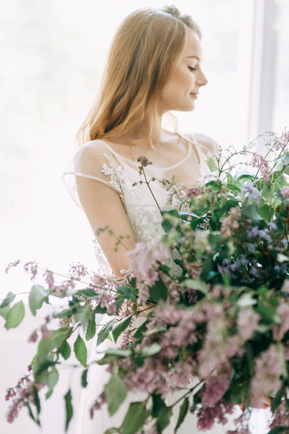  Wedding in European style. Stylish trendy bride in the Studio with a bouquet of lilacs. - 写真・画像