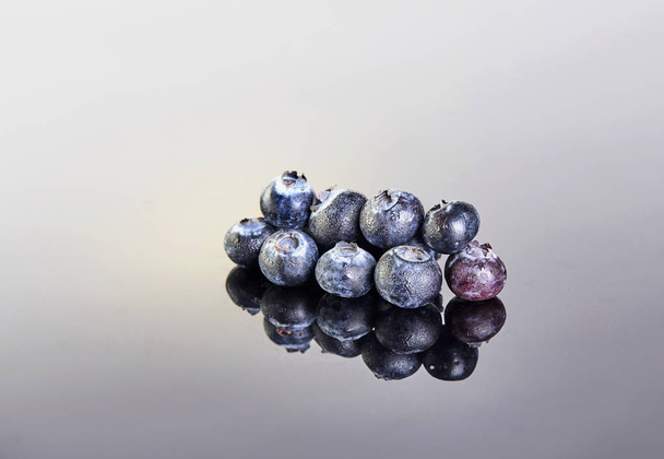Fresh blueberries covered in drops on a gray white background - Photo, Image