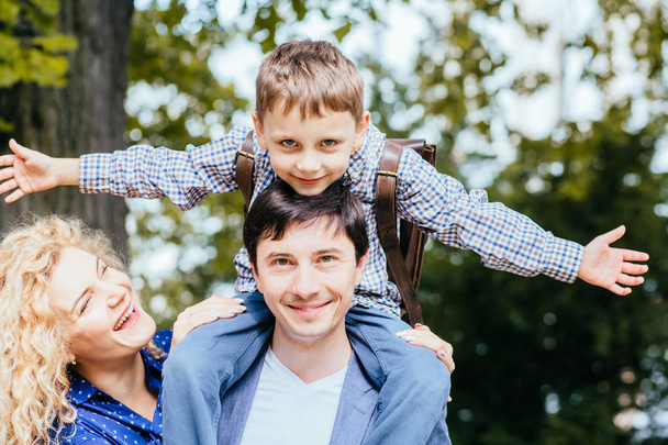 Szczęśliwa Rodzina Matka, ojciec i jego uczeń syna gra na wolnym powietrzu w parku. - Zdjęcie, obraz