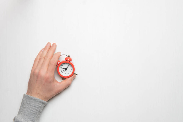 Genç bir adamın eli kırmızı çalar saat tutar. Zaman, uyku, aw - Fotoğraf, Görsel