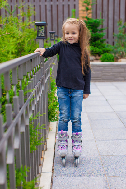 Little cute girl on roller skates in front of her home - Photo, image