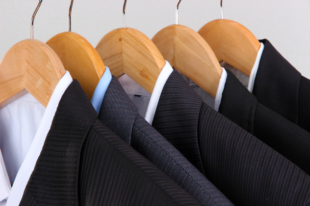 Suits with shirts on hangers on light background - Zdjęcie, obraz