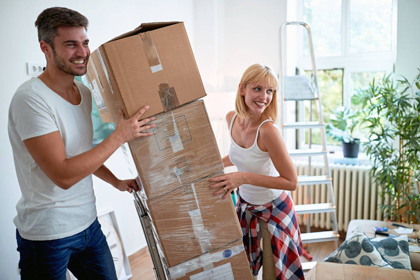 Young smiling man and woman moving into a new home - Photo, image