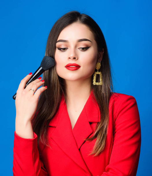 Hiding all imperfections. Perfect skin tone. Makeup artist concept. Looking good and feeling confident. Gorgeous lady makeup red lips. Fashion model tv host. Attractive woman applying makeup brush - Foto, Imagem