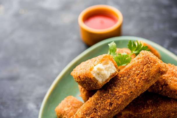 Kurkuri paneer fingers or pakora/pakoda snacks also known as Crispy Cottage Cheese Bars, served with tomato ketchup as a starter. selective focus - Foto, imagen