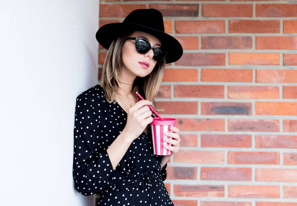 женщина в шляпе и солнцезащитных очках с напитком
 - Фото, изображение
