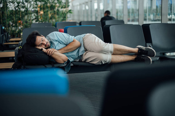 Le gars à l'aéroport attend le départ, endormi
 - Photo, image