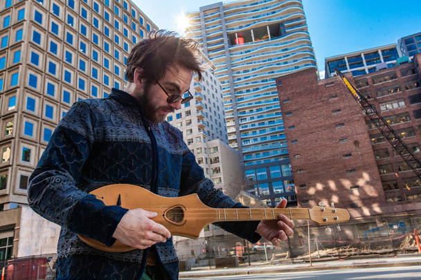 Μουσικός παίζει μικρή κιθάρα στο πάρκο της πόλης - Φωτογραφία, εικόνα