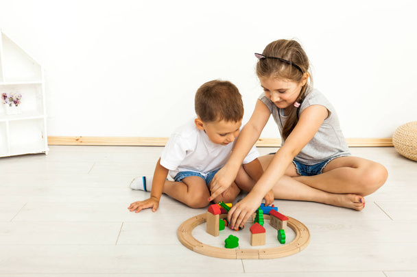 cute little girl and boy playing with toys by the home - Foto, Imagem