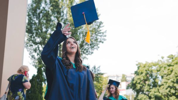 Απόφοιτοι Πανεπιστημίου πετάνε καπέλα αποφοίτησης στον αέρα. Ομάδα - Φωτογραφία, εικόνα