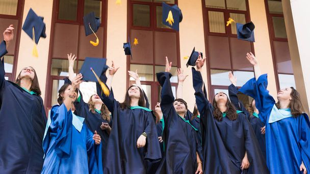 Απόφοιτοι Πανεπιστημίου πετάνε καπέλα αποφοίτησης στον αέρα. Ομάδα - Φωτογραφία, εικόνα