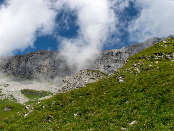夏の風光明媚な日に神秘的な霧に覆われた高い山のピーク,スイス  - 写真・画像
