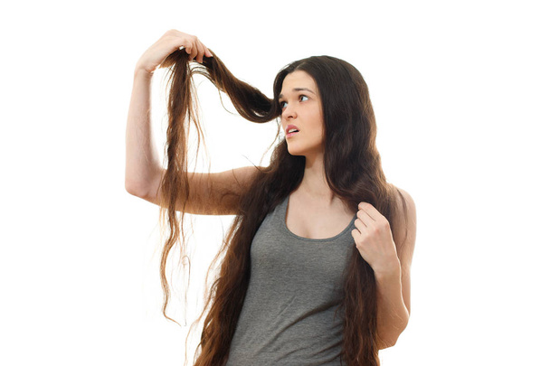 Young woman with problem hair. White background - Photo, Image