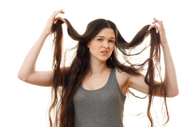 Young woman with problem hair. White background - Valokuva, kuva