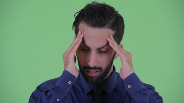 Face of stressed young bearded Persian businessman having headache - Footage, Video