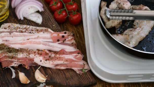 Cuisine maison. Le porc ou le bœuf rôti dans une casserole de cuisine est transformé avec des pinces à viande. Tomates, oignon, ail. Style rustique
. - Séquence, vidéo