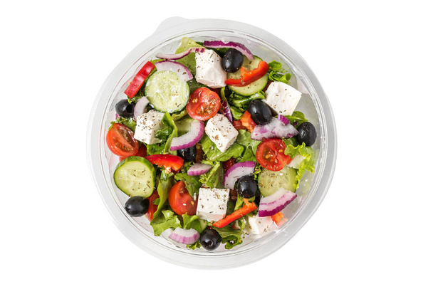 frischer griechischer Salat in einer Plastikverpackung zum Mitnehmen isoliert auf weißem Hintergrund - Foto, Bild