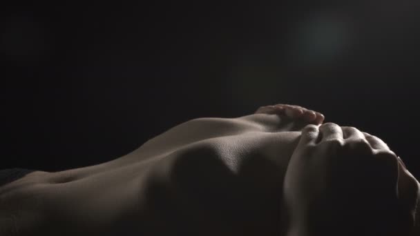 Wideo z leżącego szczupła kobieta obejmujące piersi - Materiał filmowy, wideo