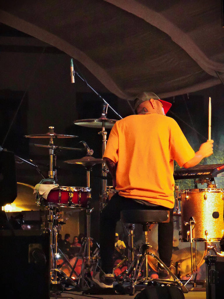 Een man speelt de drums gezien van achteren. - Foto, afbeelding