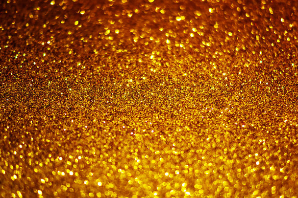 Festive abstract gold glitter texture background with shiny sparkle. Colorful defocused background with glittering and sparkling spots. Suitable for christmas,new year,chinese new year and designs - Photo, Image