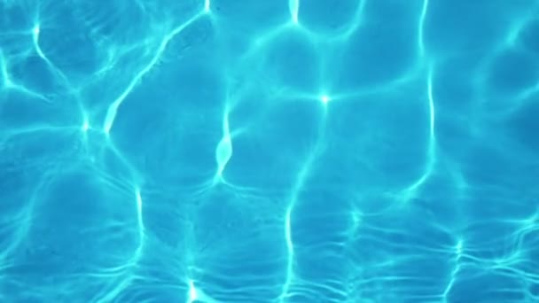 スローモーションでパドリング池で明るく輝く太陽の光の星雲を持つ放射状の水のスロモの豪華な背景ビューで泳ぐ光の光の完全な海水 - 映像、動画