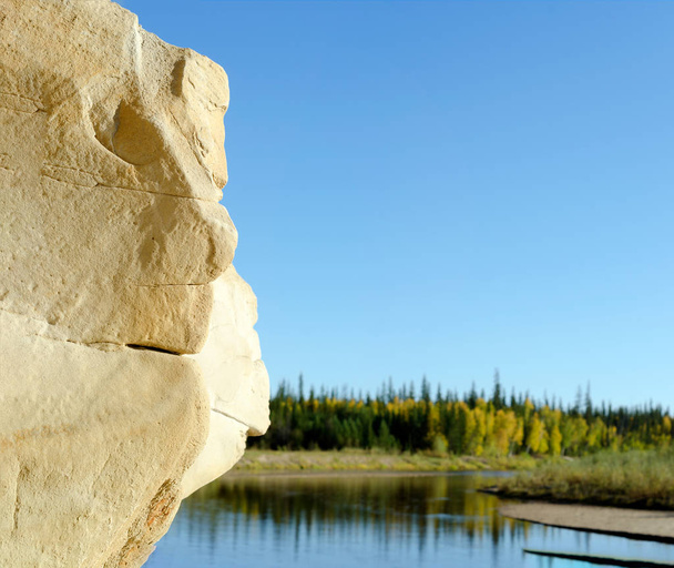 Forma de erosión de la arcilla de relieve en forma de cabezas de Golem - un rostro humano en la montaña en el fondo de la tundra y el río de la tundra norte de Yakutia
. - Foto, Imagen