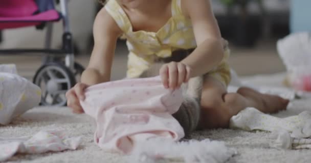 Κορίτσι βάζοντας τα ρούχα στη γάτα - Πλάνα, βίντεο