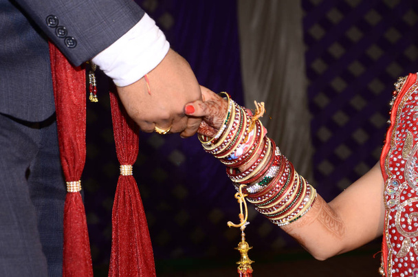 Ινδικό ζευγάρι τελετή δαχτυλιδιών. Ινδικό τελετουργικό δει πριν από το γαμήλιο χέρι ταρακουνήσει μαζί νύφη με τον γαμπρό. Το Ινδικό αγαπησιάκι παντρεύεται. όμορφη νύφη χέρια με mehndi. - Φωτογραφία, εικόνα