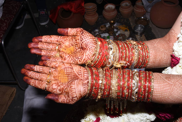 Ινδικό ζευγάρι τελετή δαχτυλιδιών. Ινδικό τελετουργικό δει πριν από το γαμήλιο χέρι ταρακουνήσει μαζί νύφη με τον γαμπρό. Το Ινδικό αγαπησιάκι παντρεύεται. όμορφη νύφη χέρια με mehndi. - Φωτογραφία, εικόνα