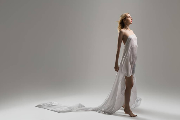 Slim blonde wrapped in white cloth shot - Фото, зображення
