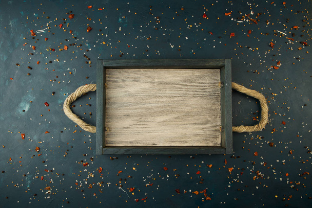 THE BOX ON A DARK BACKGROUND. WOODEN TRAY WITH ROPE HANDLES ON A DARK TEXTURED BACKGROUND. - Fotografie, Obrázek
