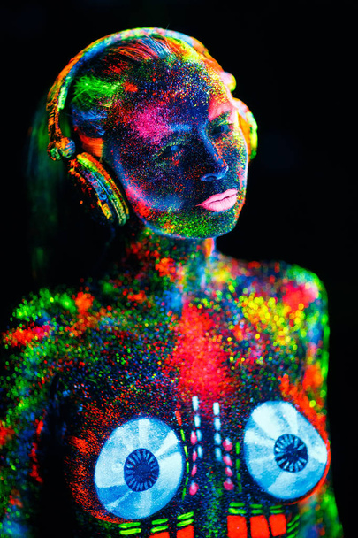 Έννοια. Στο σώμα ενός κοριτσιού που ζωγράφισε το κατάστρωμα για DJ. Μισόγυμνη κορίτσι ζωγραφισμένο σε UV χρώματα - Φωτογραφία, εικόνα
