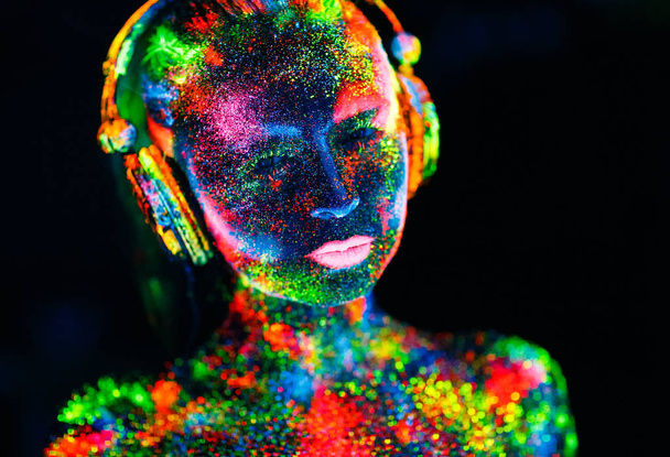 Concept. On the body of a girl painted DJ deck. Half-naked girl painted in UV colors - Photo, Image