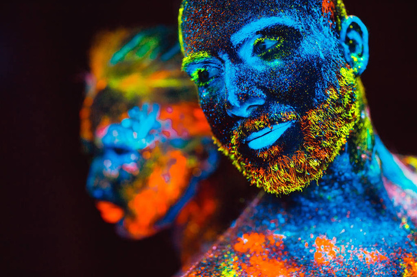 Portrait of a pair of lovers painted in fluorescent powder - 写真・画像