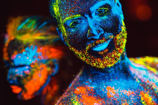 Portrait of a pair of lovers painted in fluorescent powder - Foto, Imagen