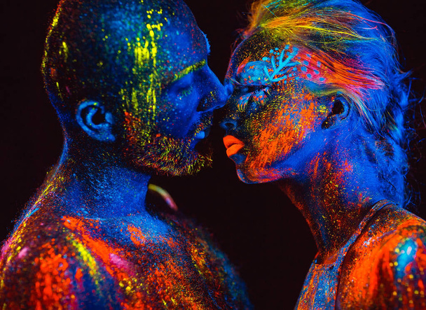 Portrait of a pair of lovers painted in fluorescent powder - Фото, изображение