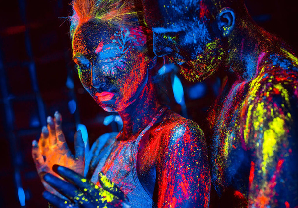 Portrait of a pair of lovers painted in fluorescent powder - Φωτογραφία, εικόνα